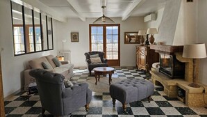 Ein Wohnzimmer mit Schachbrettfußboden, Kamin, Sofa, Sessel und Tisch.
