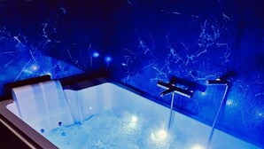 A rectangular hot tub with a marble-like wall in the background. - La traversière the secrets of desire (Villeneuve-sur-Lot)