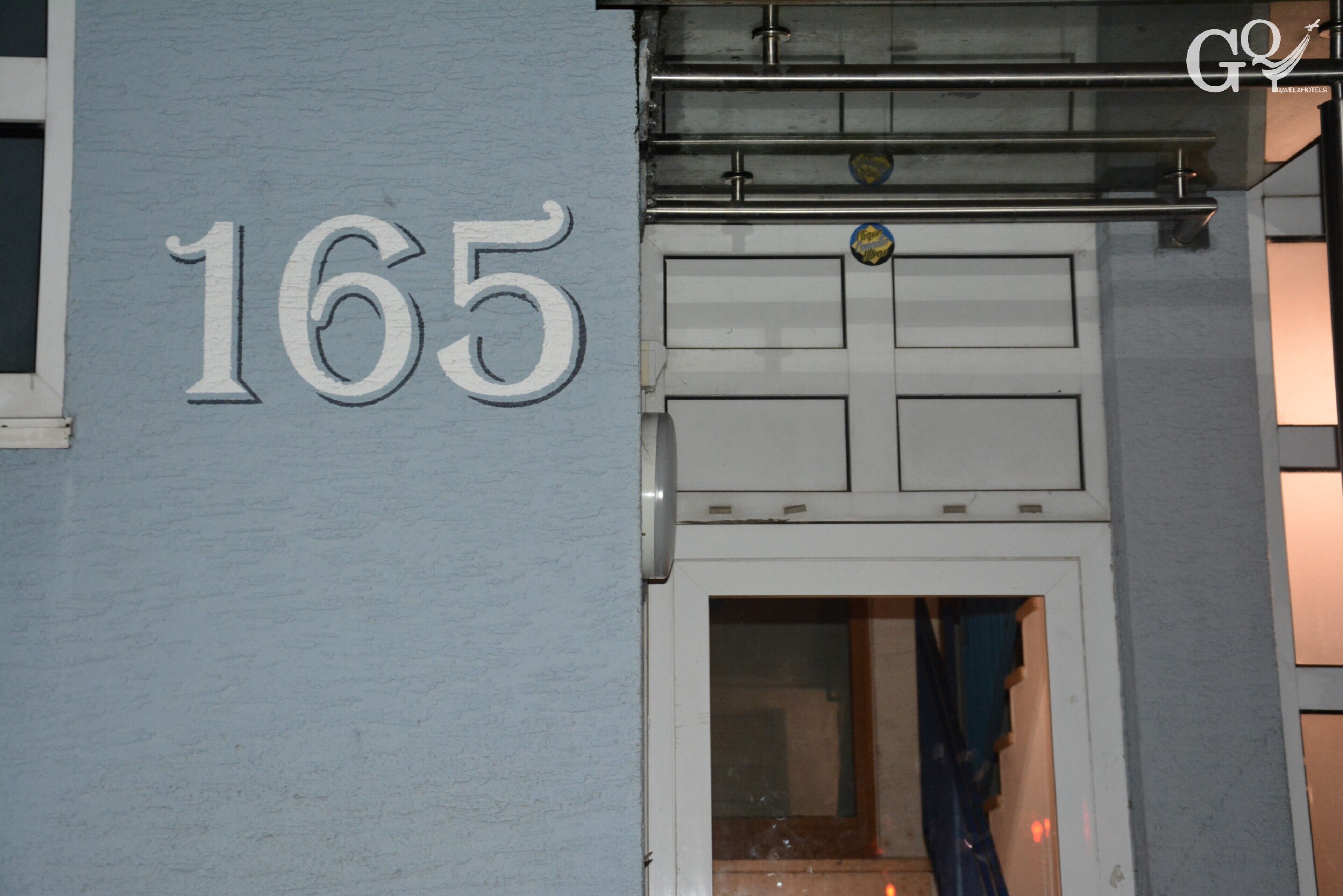 Fachada de edifício com o número 165 em destaque.