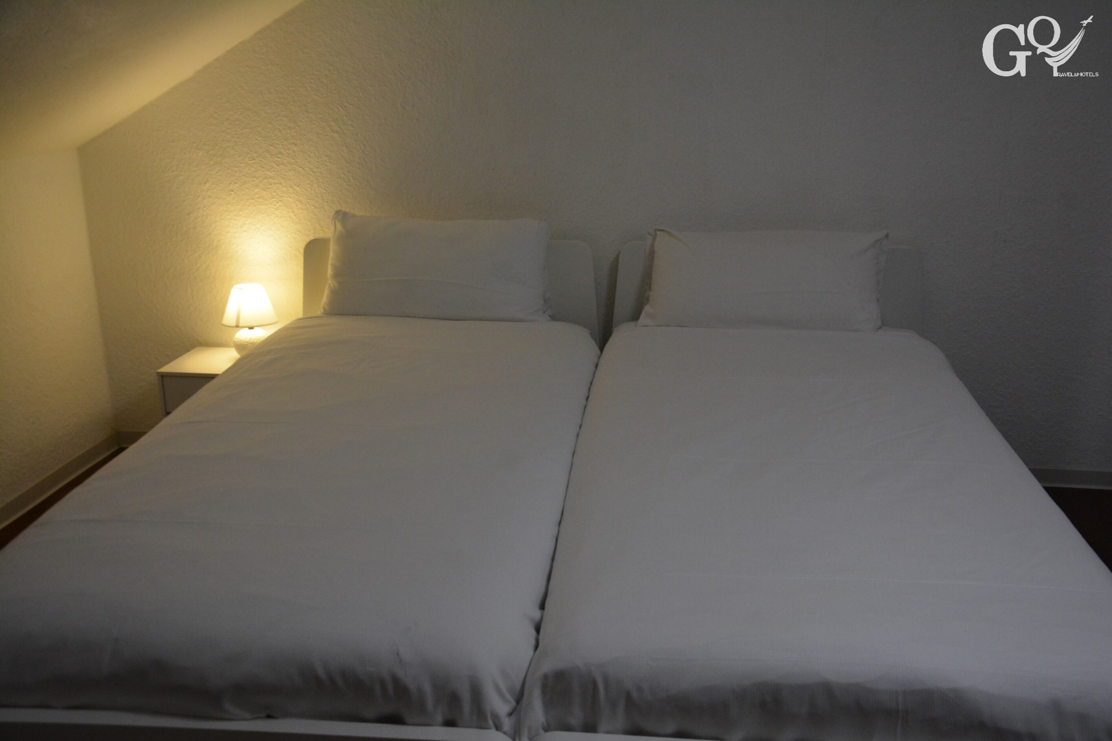 A twin bed with white bedding in a hotel room.