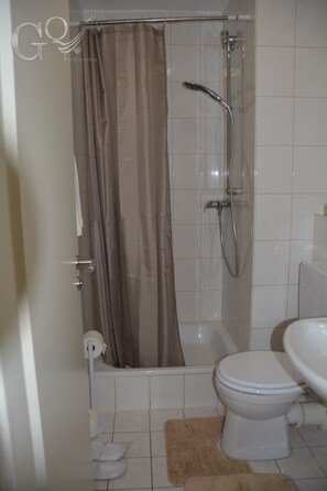 Deluxe studio suite | Badkamer | Een douche, een haardroger, pantoffels, handdoeken