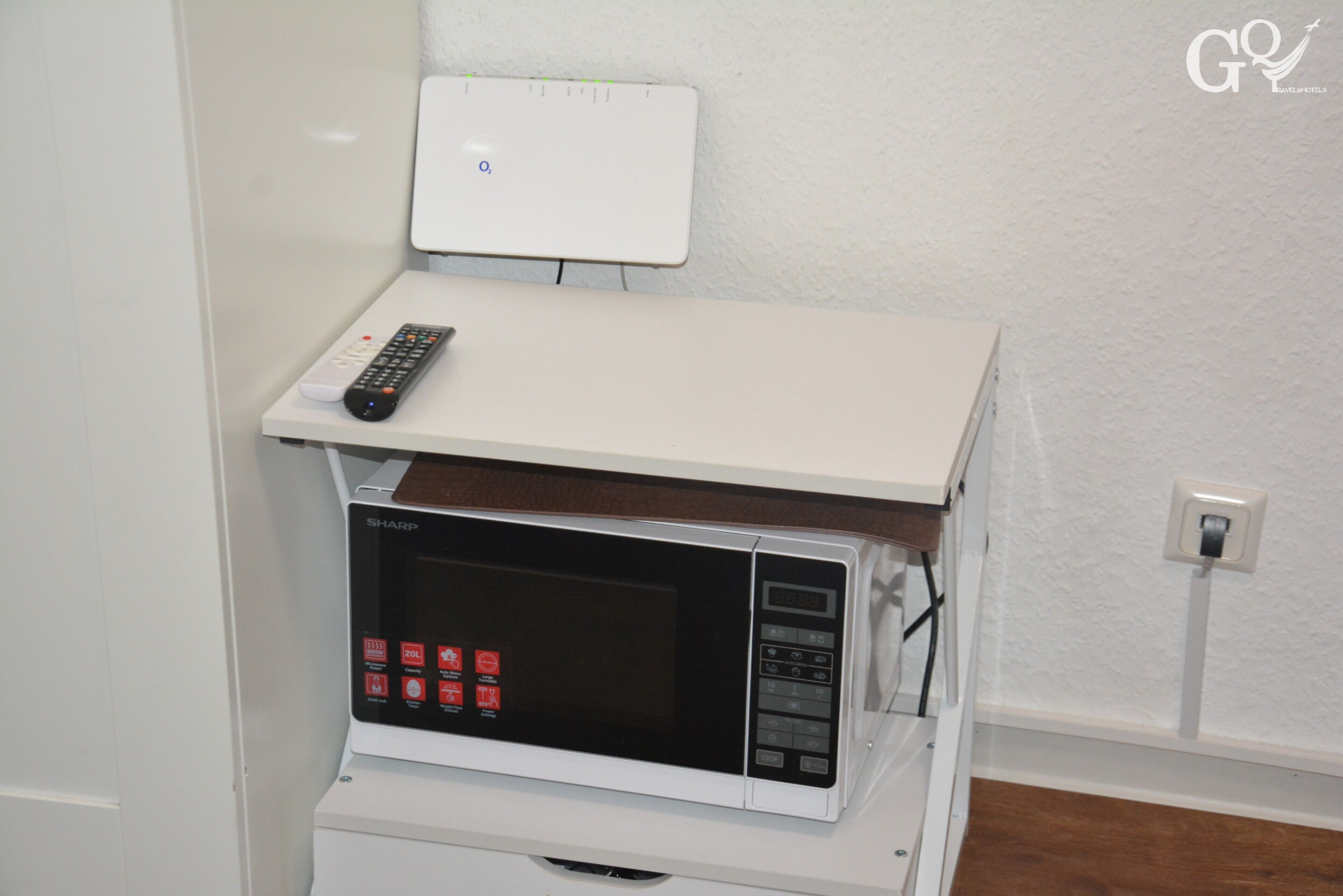 Un forno a microonde con un pannello di controllo e un telecomando sopra.
