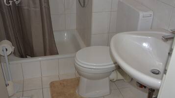 Une salle de bain avec une baignoire, des toilettes et un lavabo.