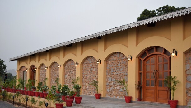 Un bâtiment doté d’une façade en pierre, de fenêtres en arc de cercle et d’une porte en bois.