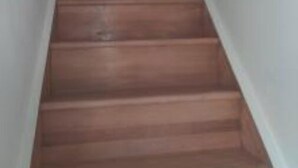 A wooden staircase with white walls and a red heart symbol on the wall at the top. - Family House (Beauvais)