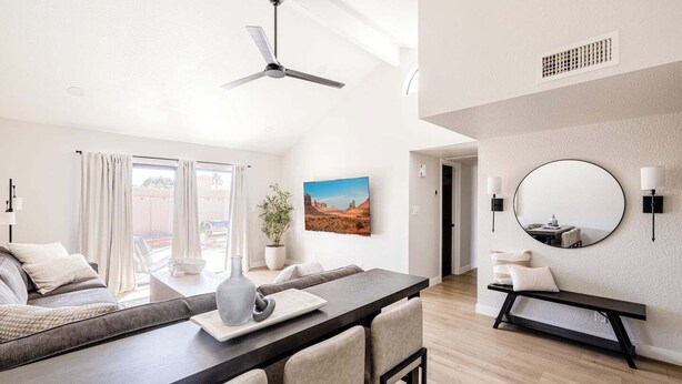 Un salon moderne comprenant un coin repas, un grand miroir et une vue sur l’extérieur.