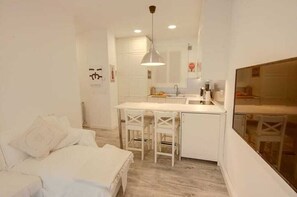 A compact room with a bed, a small kitchenette, and a dining area. - Renovated apartment in a romantic neighborhood in San Sebastián (Donostia-San Sebastián)