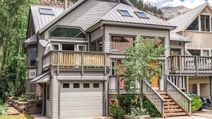 A two-story house with a garage, a balcony, and a staircase leading to the upper floor. - Tomboy Townhome-Curate Telluride, Near Market, Walk to Ski, Town, Modern (Telluride)