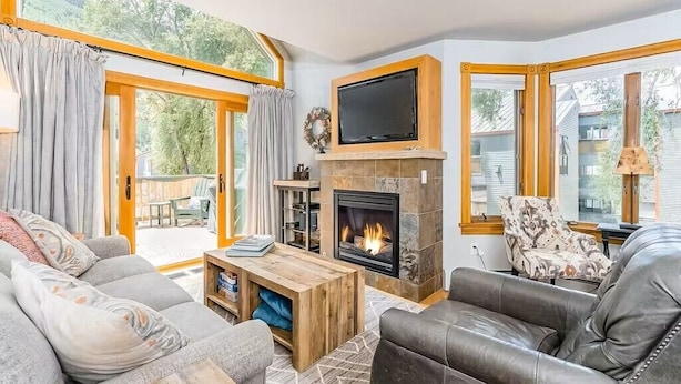 A cozy living room with a fireplace, comfortable seating, and large windows. - Tomboy Townhome-Curate Telluride, Near Market, Walk to Ski, Town, Modern (Telluride)