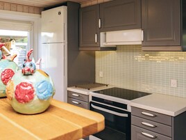 Cocina con refrigerador, horno, microondas y salpicadero de azulejos.
