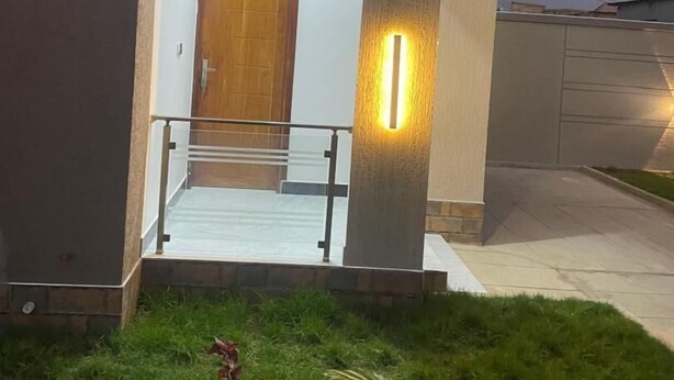 A modern house with a front door, a small porch, and a well-maintained lawn. - La Million Palace (Dodoma)