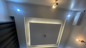 A modern room with a recessed ceiling light, a built-in air conditioning unit, and a staircase. - La Million Palace (Dodoma)