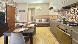Cocina moderna con comedor, que incluye estufa, armarios y un salpicadero de azulejos.