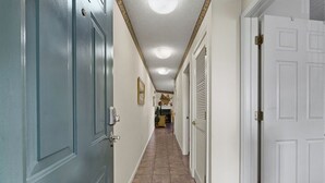 A hallway with a light blue door on the left, a white door on the right, and a tiled floor. - One Bedroom, One Bath Condo in Pigeon Forge, City View,  A couple's getaway (Pigeon Forge)