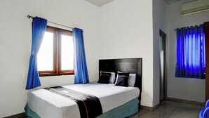 Une chambre à coucher avec un lit, des rideaux et une fenêtre.