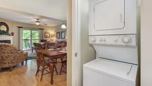 A room with a dining table, chairs, a white appliance, and a ceiling fan. - Three bedroom, three bath condo| Pigeon Forge| Close to Dollywood| Sleeps 8 (Pigeon Forge)