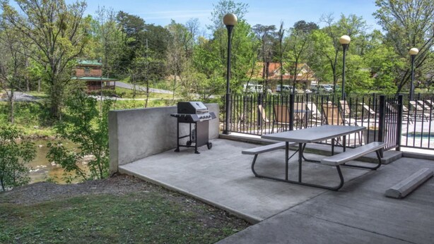 A patio area with a barbecue grill, picnic table, and outdoor seating. - Three bedroom, three bath condo| Pigeon Forge| Close to Dollywood| Sleeps 8 (Pigeon Forge)