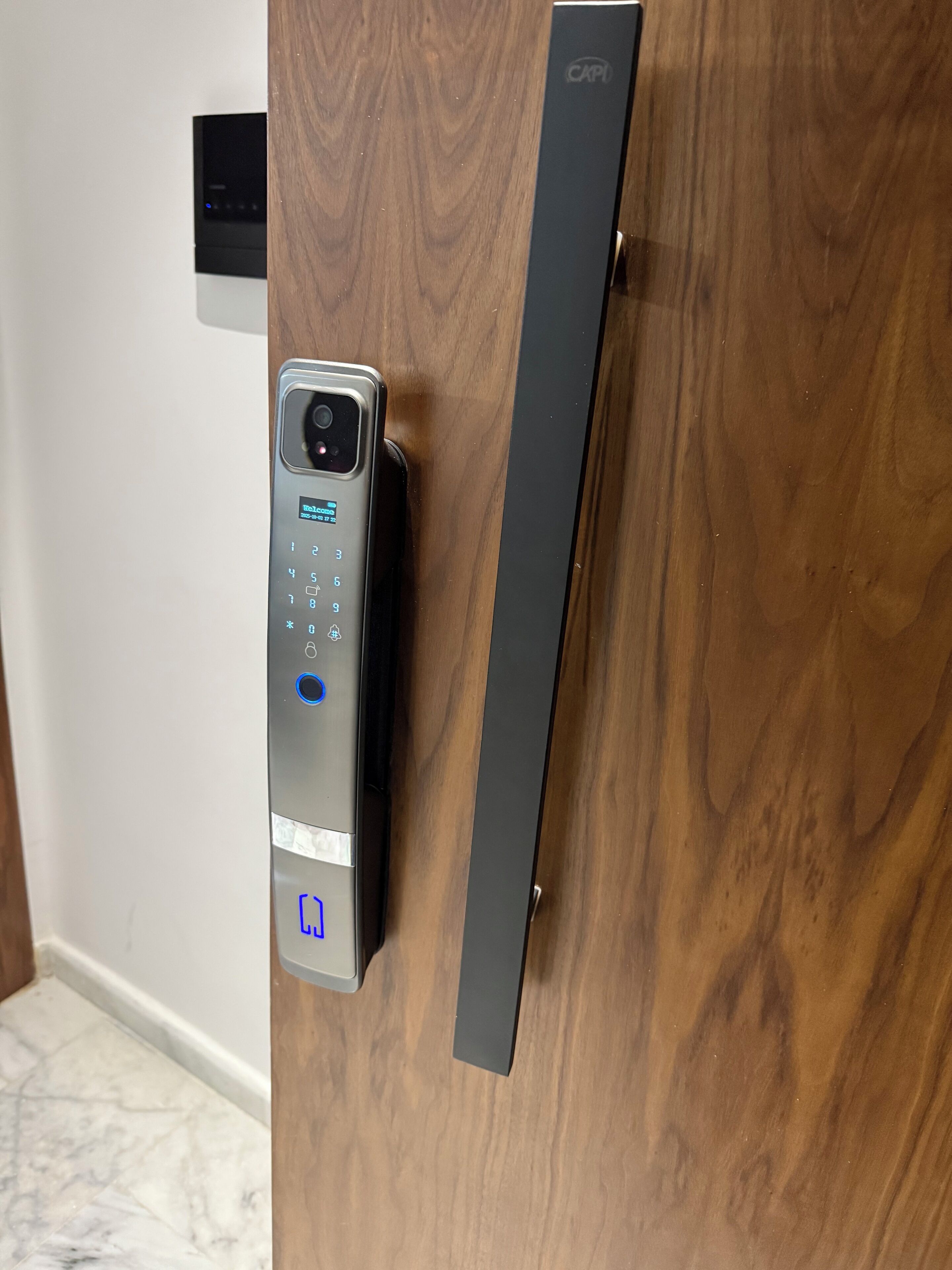 Una farratge electrònica amb teclat i ranura per targeta, muntada sobre una porta de fusta.