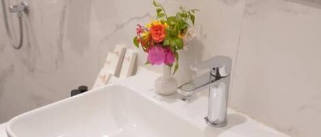 A bathroom with a white sink, a mirror, and a towel rack.
