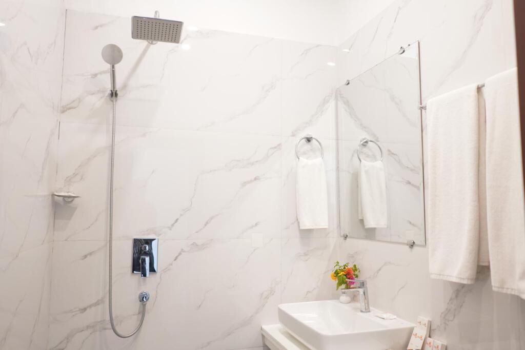A modern bathroom with a shower, a sink, and a mirror.