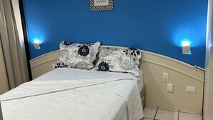 Ein Schlafzimmer mit einem Bett, einer blauen Wand und einem Schild mit der Aufschrift 'ON TEMP HOJE AMANHA'.
