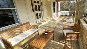 A wooden deck with a sofa, chairs, and a table. - Stay Salty: Recently Renovated Historic Home l Centrally Located I Pet Friendly (Ocracoke)
