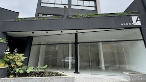 Een modern gebouw met een glazen ingang en een bord met de tekst 'ANDRAUS'.