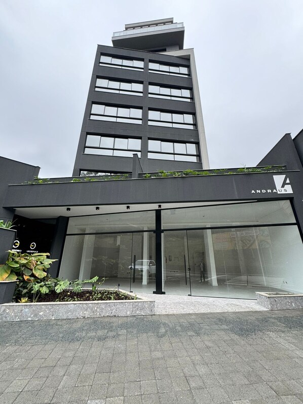 Un bâtiment moderne avec une entrée en verre et une enseigne portant l’inscription « ANDRAUS ».