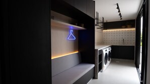 A modern kitchen with built-in appliances, a neon sign, and a recessed ceiling light. - Brand new loft next to Vila Germanica (Blumenau)