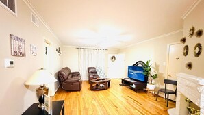 A living room with a sofa, a coffee table, a TV, and a fireplace.