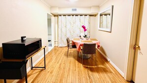 A dining area with a table, chairs, a microwave, and a door.