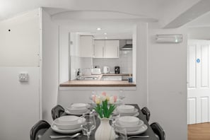 A compact kitchen with white cabinets, a countertop, and a built-in oven. - Central House, Near Train & Fun! (Worcestershire)