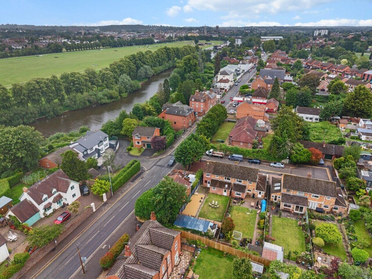 A residential area with houses, a river, and a road.