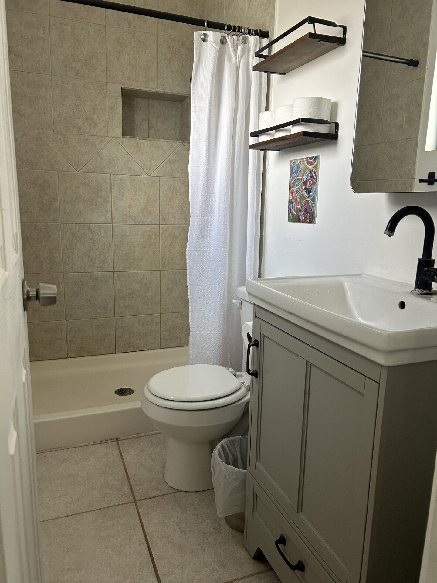 A bathroom with a shower, toilet, and sink.