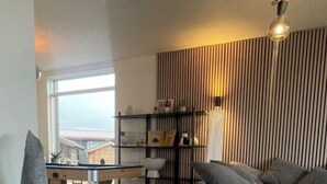 A modern living room with a sofa, a desk, and a decorative gnome. - 4-bedroom house in Höfn í Hornafirði (Höfn í Hornafirði)