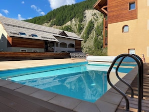 Una piscina al aire libre, una piscina climatizada