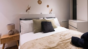 Ein Schlafzimmer mit Bett, Nachttisch, Lampe und Wanddekorationen.