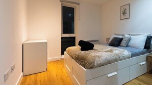 A bedroom with a bed, bedside table, and a window. - Spacious Ancoats -pool-gym-free Parking (Manchester)