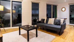 Ein modernes Wohnzimmer mit Sofa, Couchtisch und Esstisch.