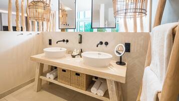 Ein modernes Badezimmer mit zwei Waschbecken, Korbwannen und einem großen Spiegel.