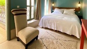 A bedroom with a bed, a chair, a rug, and a window with curtains. - Romantic Private Little Riad in Heart of Marrakech Medina (Marrakesh)