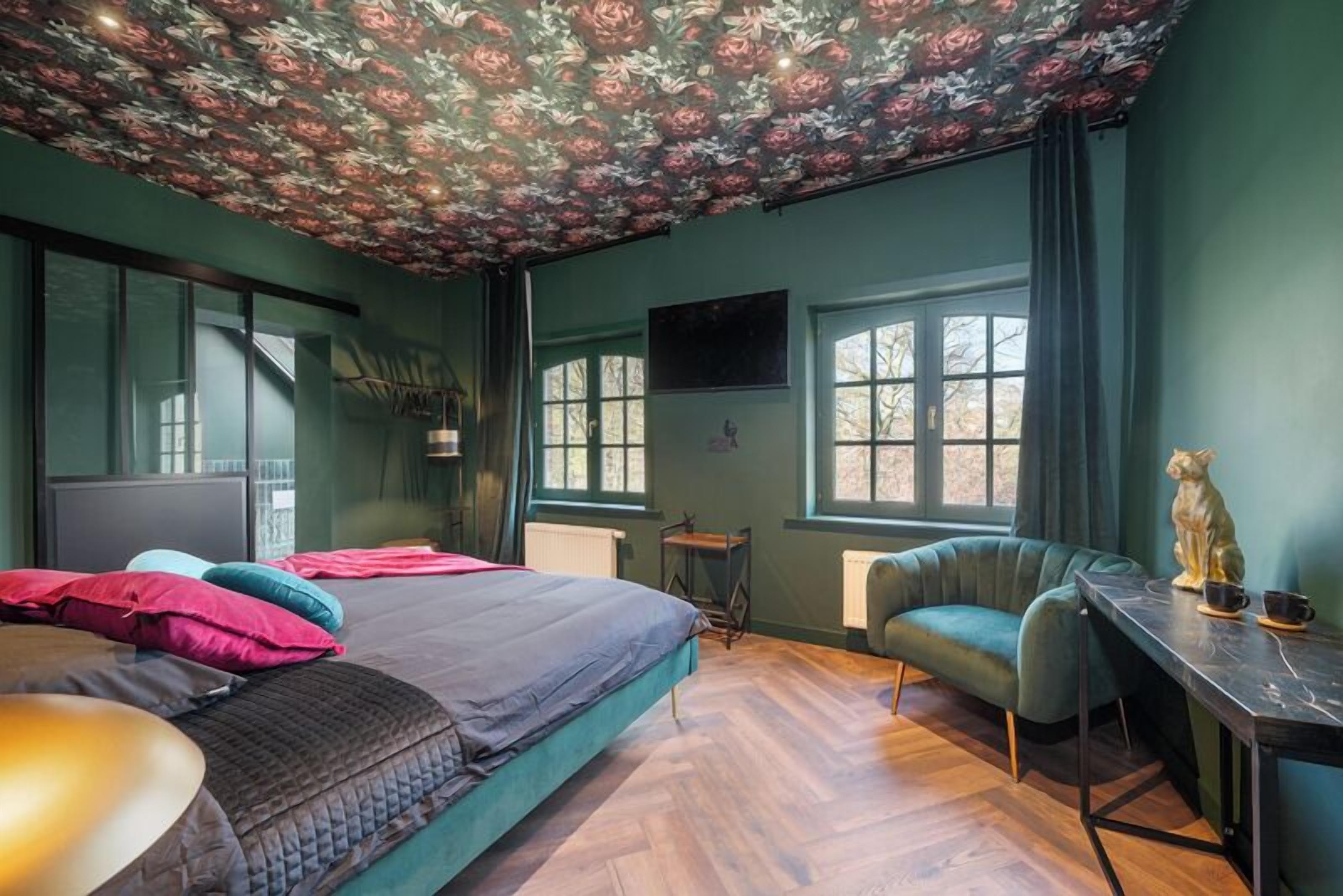 Ein Schlafzimmer mit Bett, Schreibtisch, Stuhl und Fenster.