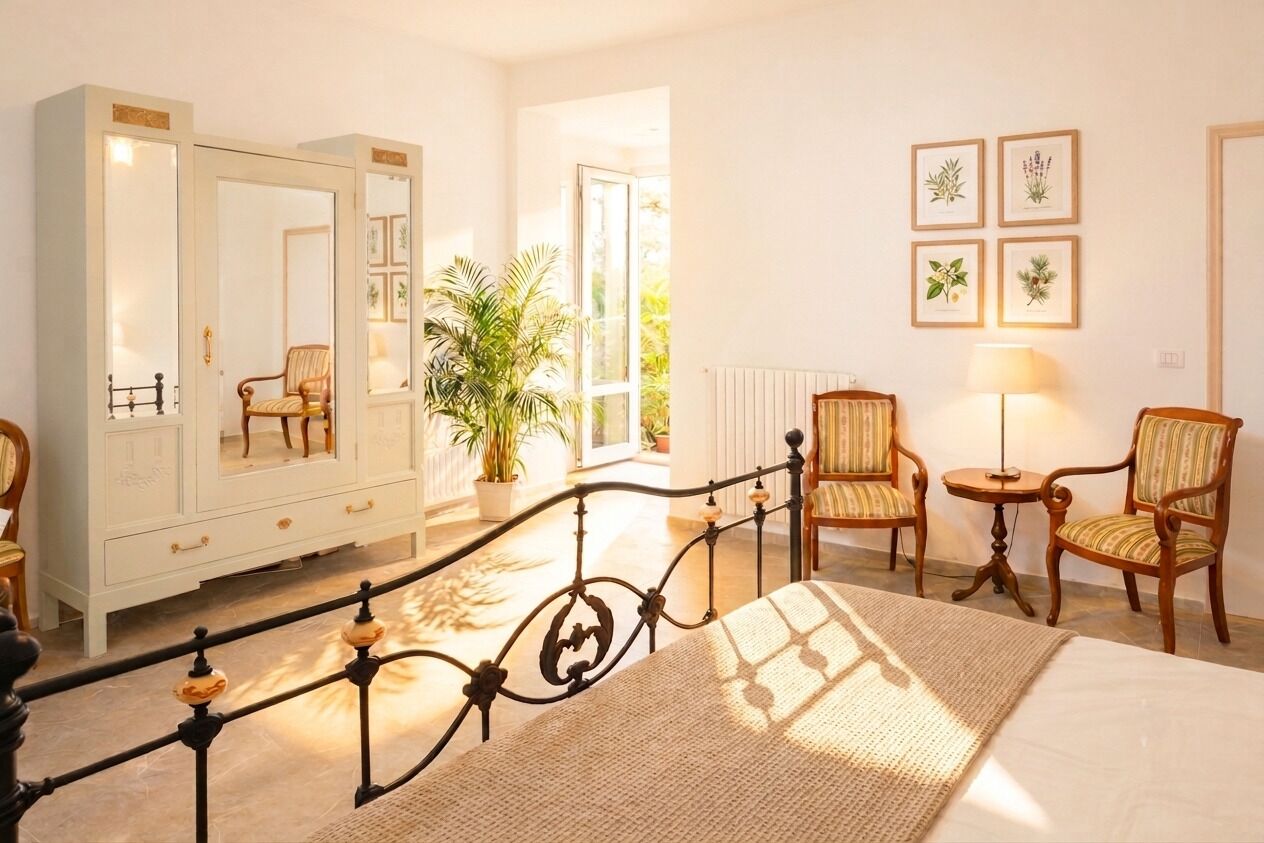 A bedroom with a bed, a wardrobe, a mirror, a chair, a table, and a potted plant.