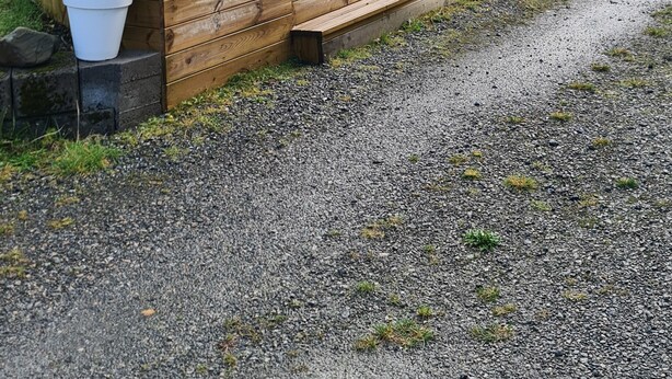 A wooden deck with chairs and a swing set, surrounded by a gravel path and a house in the background. - Cozy vacation apartment in central Norway with mountains and sea on your doorstep (Trøndelag)