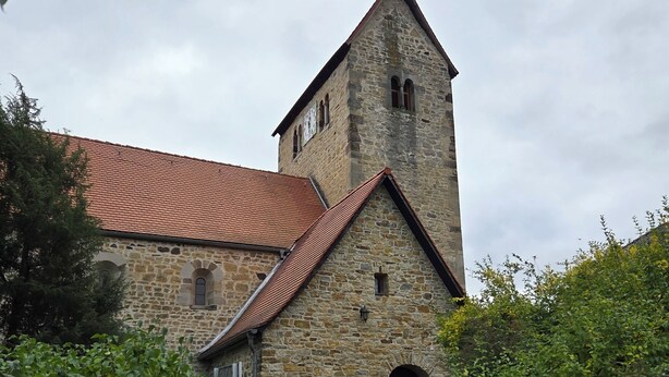 A stone church with a red-tiled roof, a bell tower, and a bench in front. - Hedel vacation apartment (Halle (Saale))