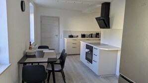A compact kitchen with a dining area, a built-in oven, and a microwave. - Hedel vacation apartment (Halle (Saale))