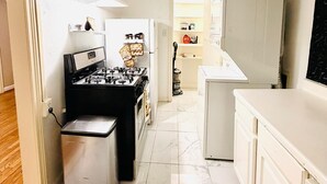 A narrow kitchen with a stove, oven, and a small trash bin. - Private 2BR and 1BA Condo in Texas Medical Center Houston - Apartment 6710-2 (Houston)