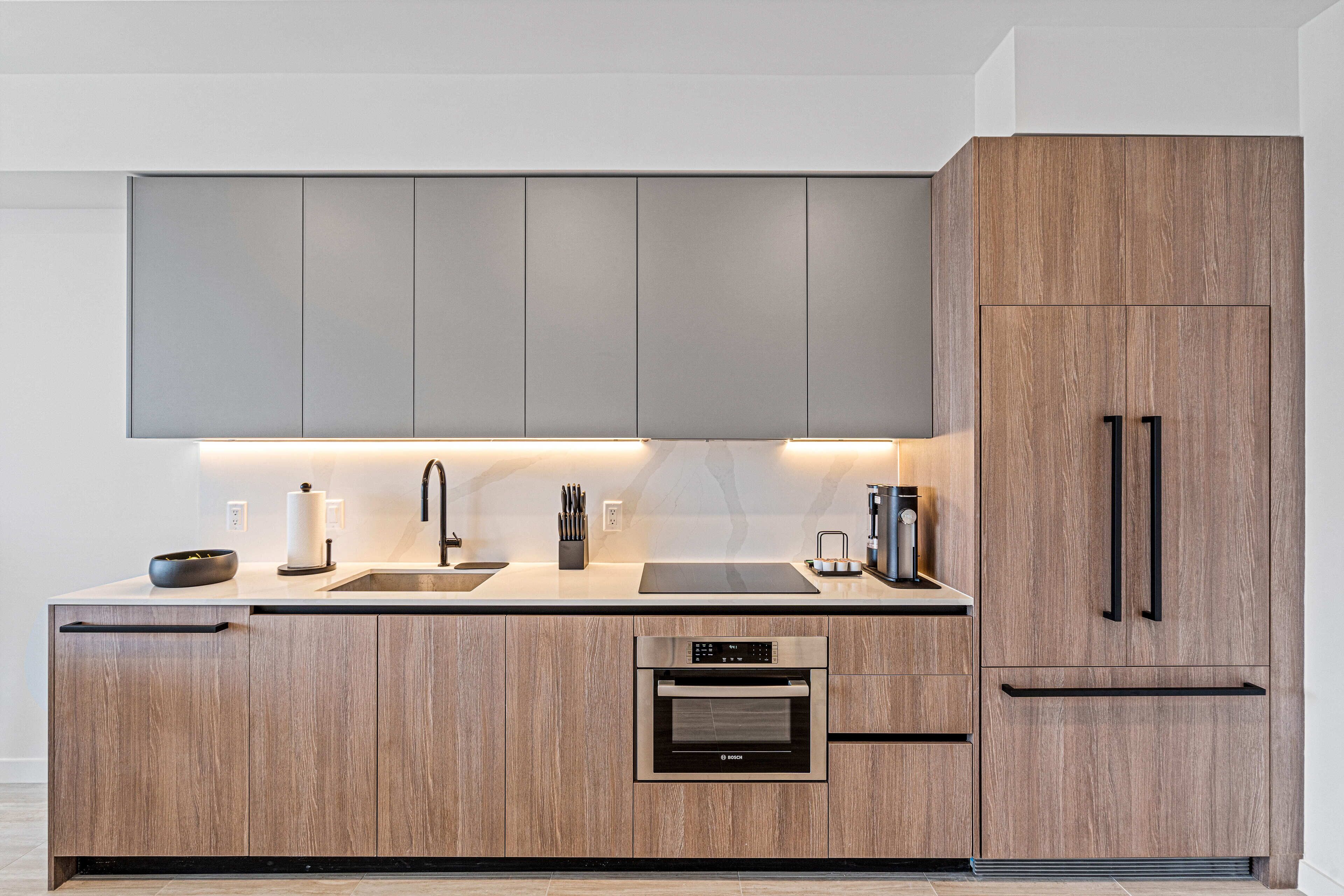 Une cuisine moderne avec des meubles en bois, un four encastré et un évier.
