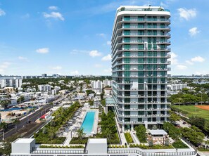 A modern high-rise hotel with multiple balconies, a swimming pool, and a view of the surrounding cityscape. - 72 Building Miami Beach Condo - We Host (Miami Beach)