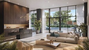 A modern living room with a sofa, coffee table, and a built-in entertainment unit. - Elegant Miami Beach Condos (Miami Beach)